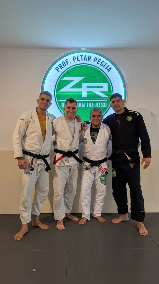 Vier Generationen ZR-Team-Schwarzgurte, aufgenommen am 9. November 2025 im ZR Team Vienna – von links: Prof. Petar Pecija, Prof. Philipp Kainz (Hocus Chokus BJJ Wien), ZR-Gründer Prof. Zé Radiola und Prof. Max Carvalho, anlässlich Philipps Schwarzgurt-Graduierung unter Prof. Petar Pecija